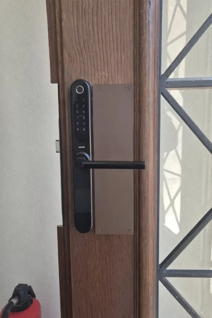 Installation professionnelle d'une garniture Arrone sur ancienne porte avec ajustements de serrurerie - serrurier Neuchâtel