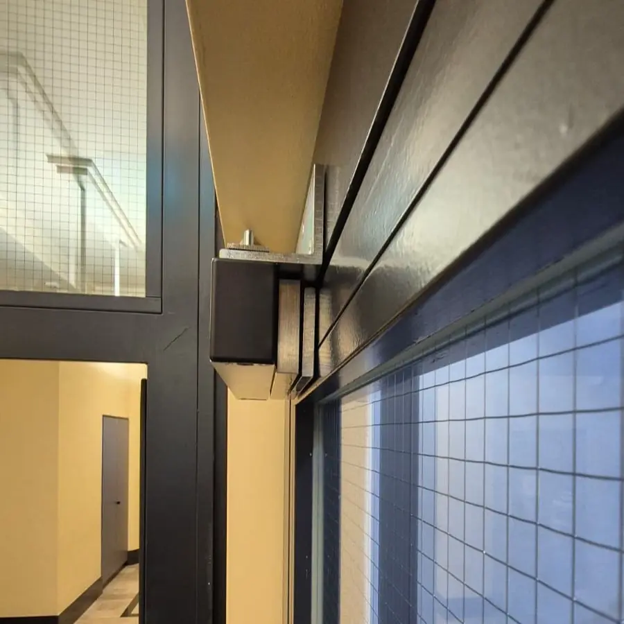 Travaux de serrurier Neuchâtel : installation d'une ventouse magnétique avec commande par bouton poussoir.