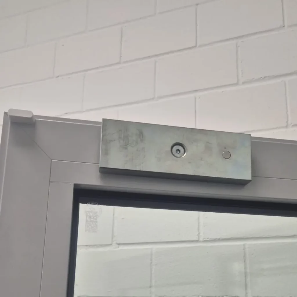 Mise en place d'une ventouse magnétique sur un dispositif de contrôle d'accès avec effet SAS, réalisée par un serrurier Neuchâtel